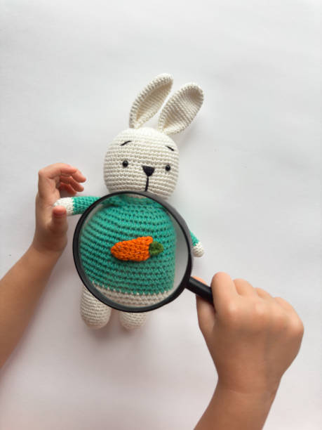 istock Child exploring amigurumi rabbit with magnifying glass and carrot design 2182553050