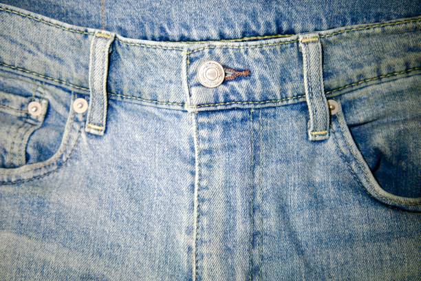 close-up of the front of blue jeans with button and belt loops