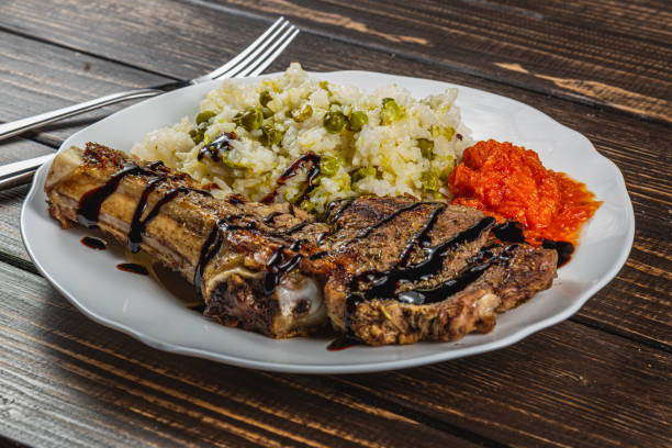 istock steak entrecote on the bone with rice and vegetables on a white plate 2182558996