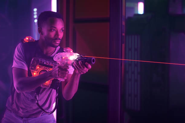 istock Young man playing laser tag game in neon-lit black light amusement center 2182561363