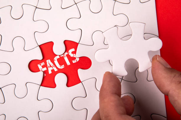 istock FACTS. White puzzle pieces on an red background 2182565483
