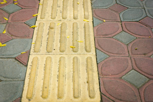 Bright yellow tactile paving for the visually impaired on the sidewalk.