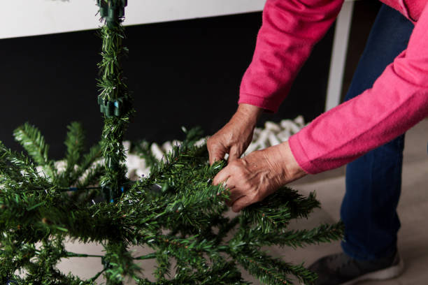 istock A woman is decorating a Christmas tree with green branches 2182578065