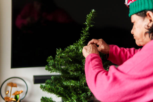 istock A woman is decorating a Christmas tree 2182578095