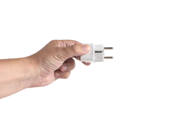 istock Hand holding out an electric plug, close-up on a white background, isolate 2182582433