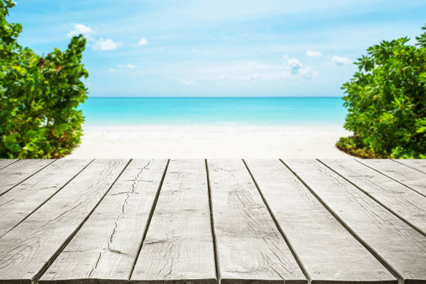 Empty wooden table top with beautiful tropical paradise beach copy space scene