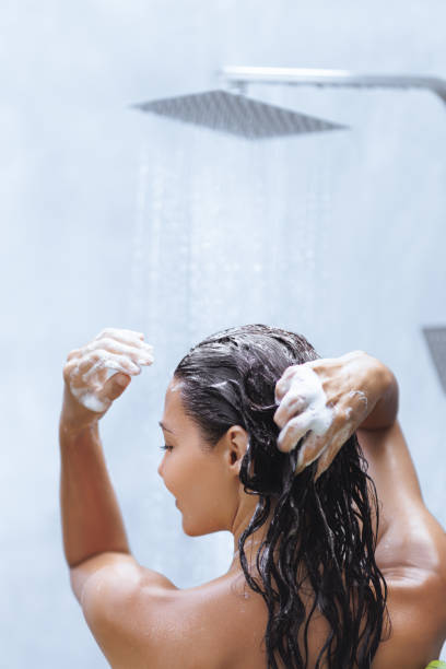 istock Woman Lathering Hair With Shampoo Under a Relaxing Rainfall Shower 2182586222