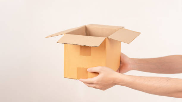 istock Hand holding cardboard box on empty background. Concept for transportation, online shopping, celebration and gift giving on special day. 2182594337
