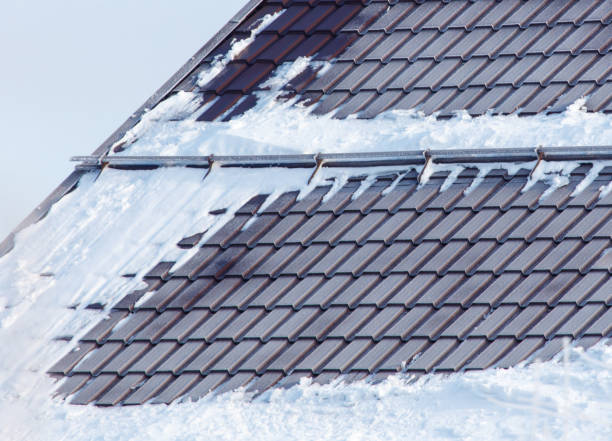 A roof covered in snow with a few spots of ice A roof covered in snow with a few spots of ice. The roof is slanted and has a triangular shape triangular solar panels stock pictures, royalty-free photos & images