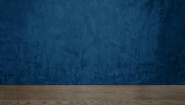 istock walnut wooden counter table at foreground with dark blue concrete wall at background. real countertop image for displayed products, natural concept. 2182601104