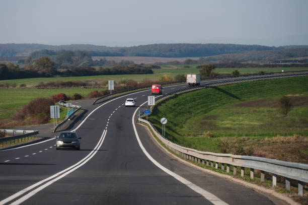 istock Vehicles on scenic rural highway with green fields 2182603867