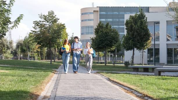 Young friends chatting on university campus footpath