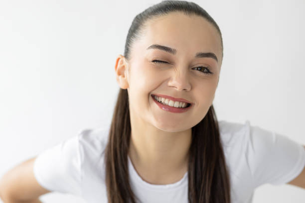 istock Young woman winking and smiling to camera 2182608719