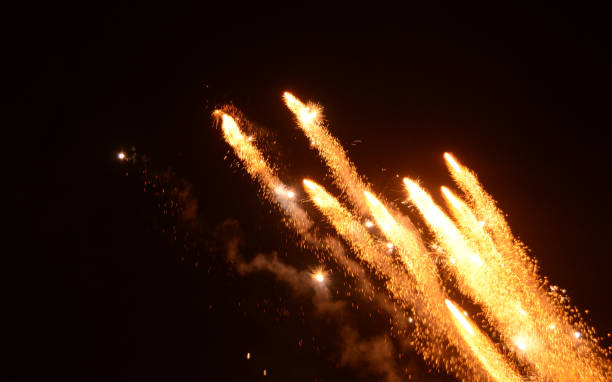 istock Yellow gold colored shining festive sparkling glittering fireworks multiple rocket explosion or many missiles attack in air in dark night horizontal backgrounds for Happy New Year, Diwali, US Independence, 4th July Australia Day celebrations backdrop 2182610273