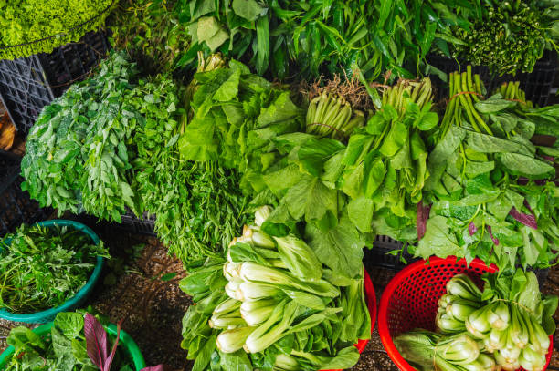 Various vegetables and herbs on the market in baskets. Asian vegetables. Vietnam Market