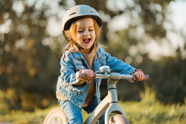 istock Excited little girl riding a bicycle 2182614940