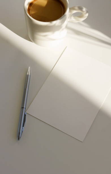 istock Card blank mockup with copy space and coffee cup with sunlight shadow top view on white background. 2182614992