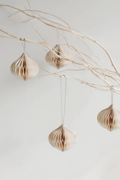 istock Christmas decor minimalistic beige background. Paper ornaments on a  branches, white wall. 2182615379