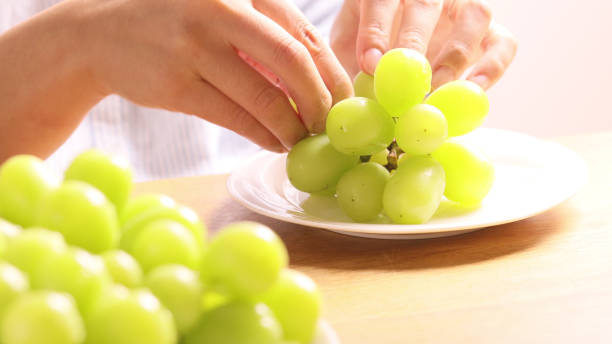 istock Hands  holding Green grapes named Shine Muscat. 2182621255
