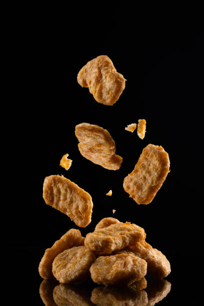 Delicious chicken nuggets on black background. Cooked or raw chicken nuggets
