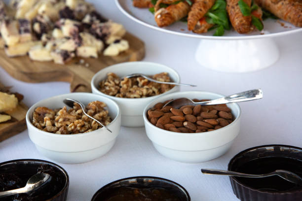 Walnuts, almonds, cheese, pastries, and jam served at a hotel continental breakfast buffet
