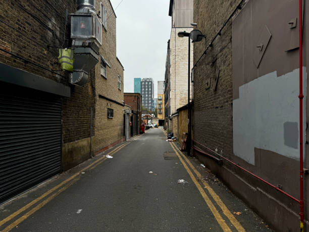 An alleyway between buildings in Walthamstow, London, with tower blocks on the horizon