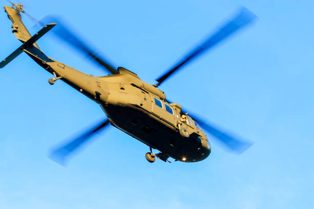 A military helicopter maneuvers skillfully in the sky, showcasing advanced aerial capabilities.