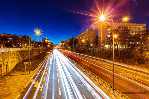 Warsaw, Poland - December 1, 2018: At night, the highways of Warsaw come alive with streaks of lights from bustling traffic, creating a dynamic display against the city’s skyline. Illuminated by streetlights and surrounding high-rises, the roads showcase the city’s modern infrastructure and vibrant pace.