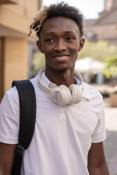 istock Young afro student smiling wearing headphones and backpack 2182635325