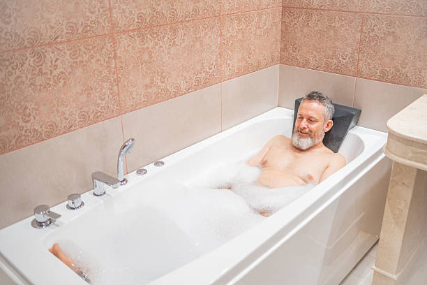 istock A mature man with a white beard is enjoying a bath in a bathroom. 2182641876