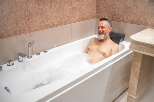 istock A mature man with a white beard is enjoying a bath in a bathroom. 2182641916