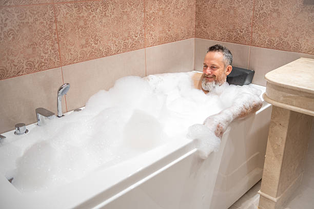 istock A mature man with a white beard is enjoying a bath in a bathroom. 2182641920