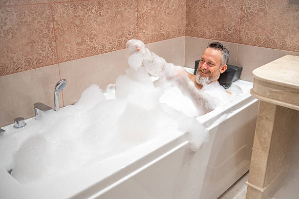 istock A mature man with a white beard is enjoying a bath in a bathroom. 2182641923