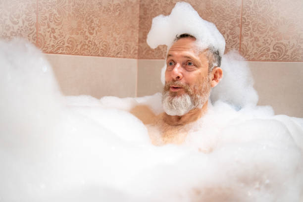 istock A mature man with a white beard is enjoying a bath in a bathroom. 2182641961