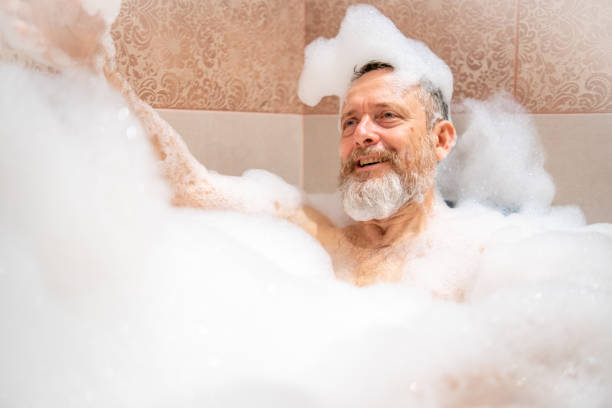 istock A mature man with a white beard is enjoying a bath in a bathroom. 2182641978