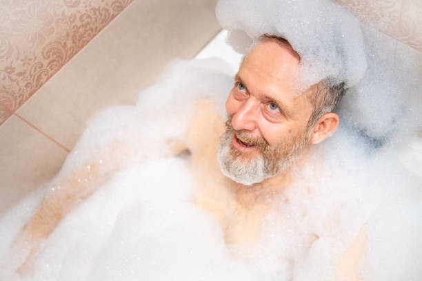 istock A mature man with a white beard is enjoying a bath in a bathroom. 2182641985