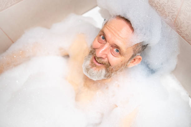 istock A mature man with a white beard is enjoying a bath in a bathroom. 2182641999