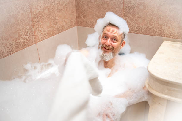 istock A mature man with a white beard is enjoying a bath in a bathroom. 2182642018