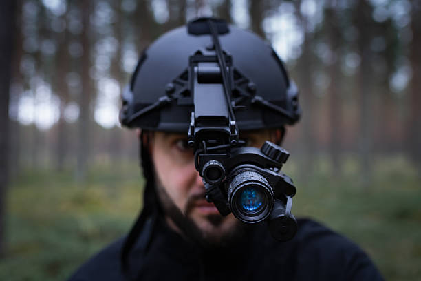 istock A man with a beard in a tactical helmet with a night vision device in a dark forest. 2182645828