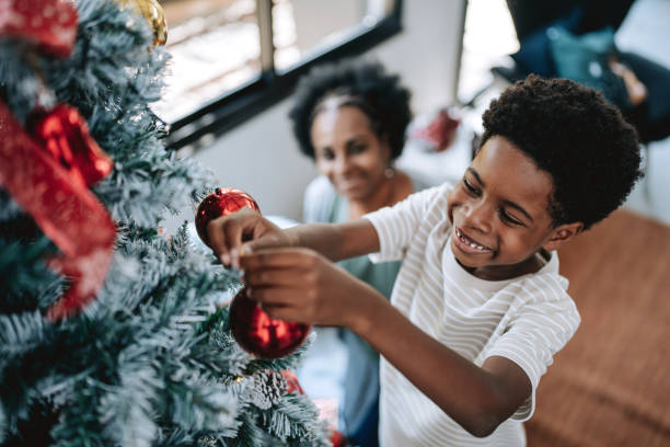 istock Mother and son placing balls on Christmas tree 2182652728