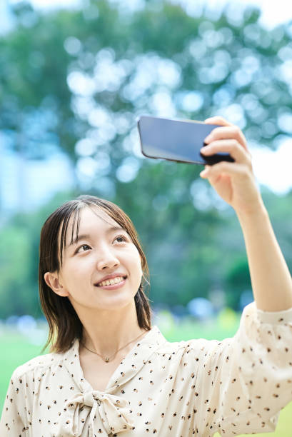 istock Young woman taking a picture with a smartphone 2182654055