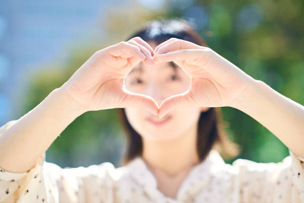 istock Young woman making a heart symbol hand sign 2182654499