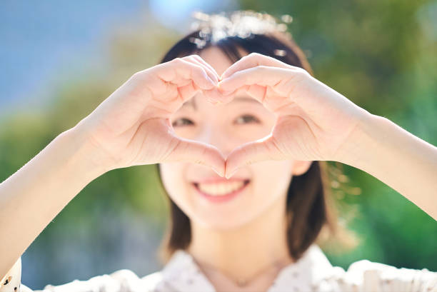 istock Young woman making a heart symbol hand sign 2182654528