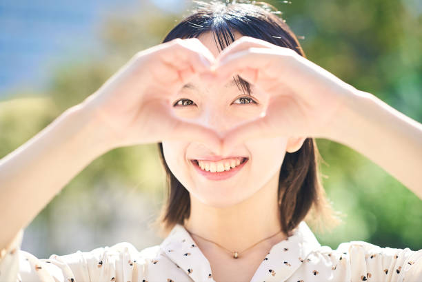 istock Young woman making a heart symbol hand sign 2182654547