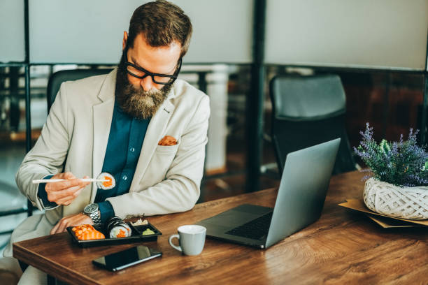 istock Businessman eating sushi in the office 2182662666