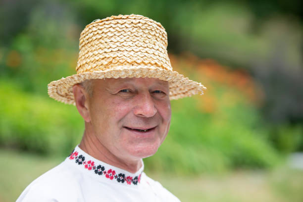 Portrait of a man with curly hair and a cloth turban smiling warmly indoors, creating a casual and peaceful mood.
