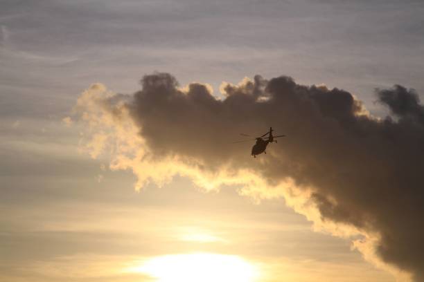 istock Helicopter Silhouetted Against a Dramatic Sunset Sky 2182664660