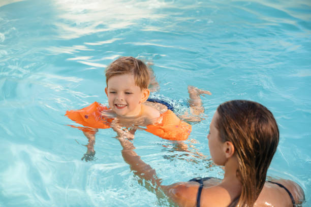 Smiling Child Learning to Swim in Pool