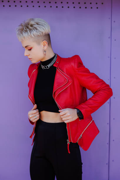 istock Stylish woman with bright makeup and silver accessories standing on purple backdrop 2182665928
