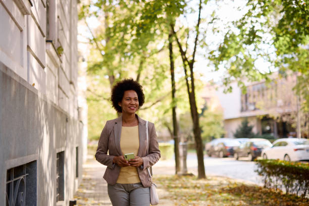 istock Smiling Woman Enjoying Autumn Walk Through Sunny Park 2182665940
